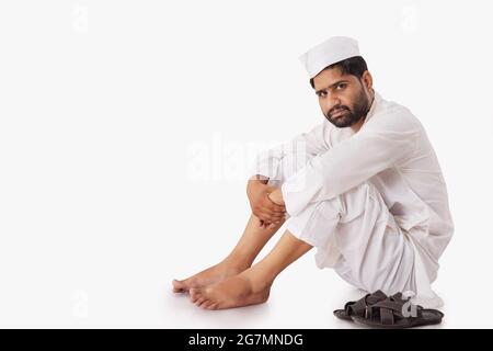 A COMMON MAN SITTING AND LOOKING AT CAMERA Stock Photo