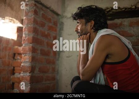 A LABOURER SITTING ALONE AND THINKING Stock Photo