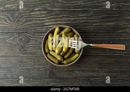 Bowl of pickles and fork on wooden background Stock Photo