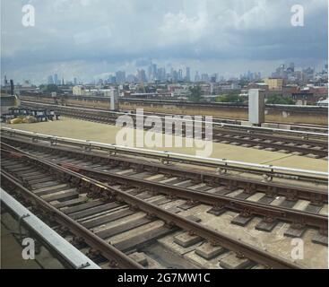 Elevated subway tracks along the F line in Brooklyn with the hazy Manhattan skyline in the distance. Stock Photo