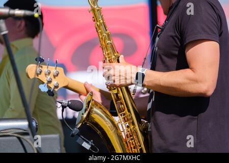 Crop man playing saxophone on street Stock Photo