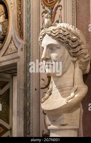 Close-up on profile of ancient marble bust of roman woman with a flower ornament on her hair Stock Photo