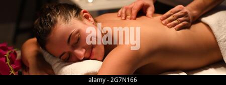 Smiling woman masseur doing back massage at spa center Stock Photo