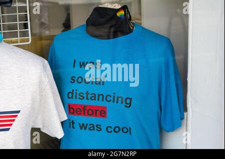 Eton, Windsor, Berkshire, UK. 14th July, 2021. A social distancing tee shirt for sale in a shop in Eton High Street. Following the announcement by Boris Johnson that the Covid-19 lockdown is ending in England from Monday 19th July, 2021, over a thousand scientists and doctors are reported to be very concerned about people no longer having to legally adhere to Covid-19 prevention measures. Credit: Maureen McLean/Alamy Stock Photo