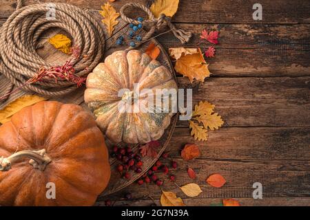 Autumn background with pumpkins and foliage on a wooden brown background. Stock Photo