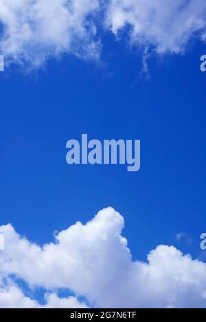 Vibrant Blue Sunny Sky between the Pure White Clouds Stock Photo