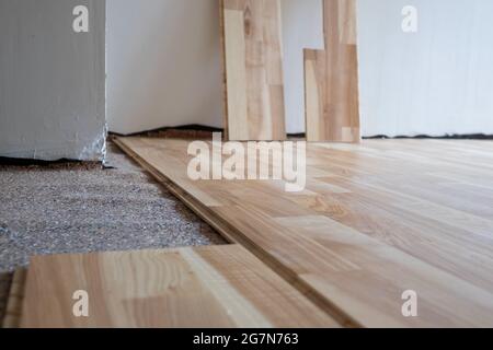 Installing wood parquet board during flooring work Stock Photo