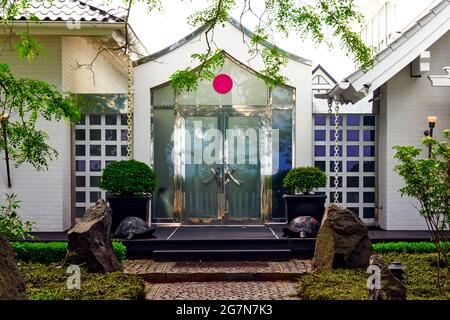 Timmendorfer Strand, Germany, June 18, 2021: Back entrance of a white japanese style house in Timmendorf, with a red circle as stylized japanese flag Stock Photo