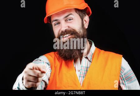 Portrait of a builder smiling. Bearded man worker with beard in building helmet or hard hat. Man builders, industry. Builder in hard hat, foreman or Stock Photo