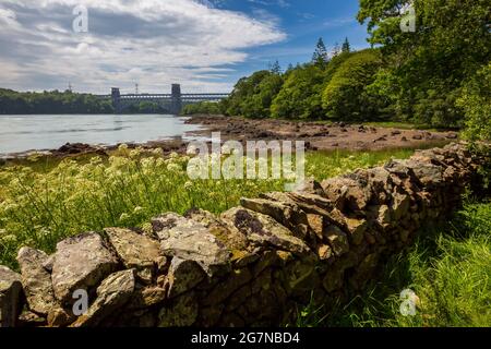 The Britannia Bridge from the shoreline of the Menai Strait at low-tide, Anglesey, North Wales Stock Photo