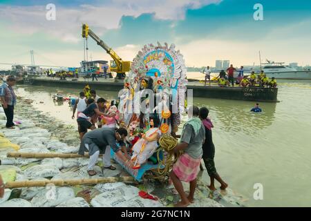 Kolkata, West Bengal, India - 30th September 2017 : Idol of Goddess Durga is being immersed at holy river Ganges, at the end of Durga Puja festival. T Stock Photo