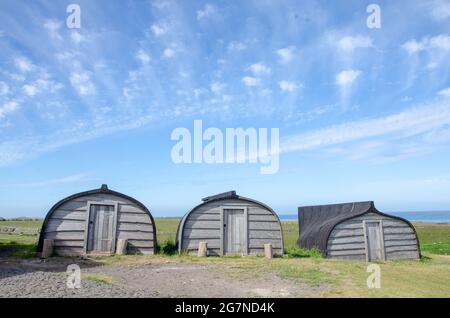 Upturned boat-shaped storage sheds near Lindisfarne Castle on Holy Island, off the Northumberland coast in the north east of England, UK. Stock Photo