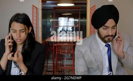 Shallow focus of an Indian man and woman talking on the phone Stock Photo