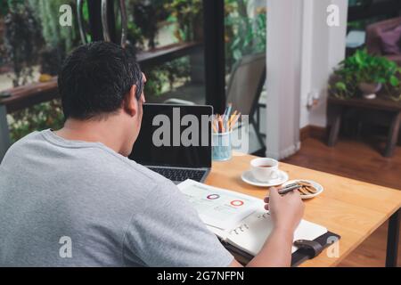 The man was seriously contemplating with the job that was sent back to be revised. While it was his holiday during the Covid-19 pandemic. Stock Photo