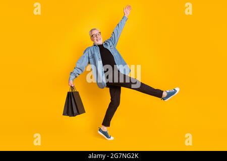 Full size profile photo of hooray grandpa go with bags wear blazer pants shoes isolated on yellow color background Stock Photo
