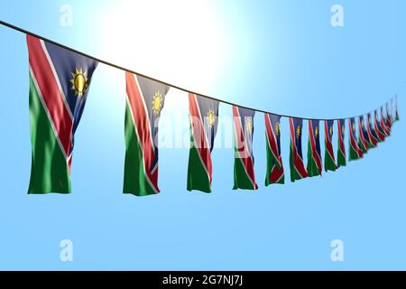 pretty national holiday flag 3d illustration  - many Namibia flags or banners hangs diagonal on rope on blue sky background with bokeh Stock Photo