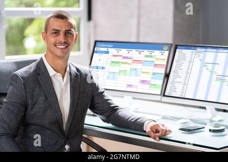 Happy Project Manager In Office Using Cloud Software On Computer Screen Stock Photo