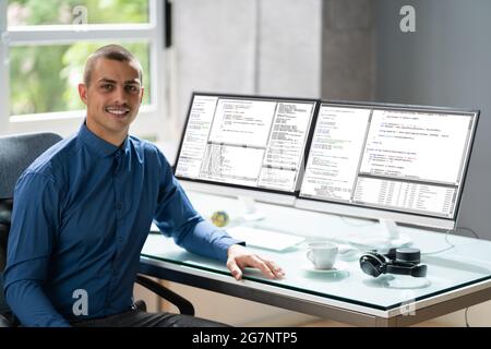 Computer Programmer Writing Program Code On Computer In Office Stock Photo