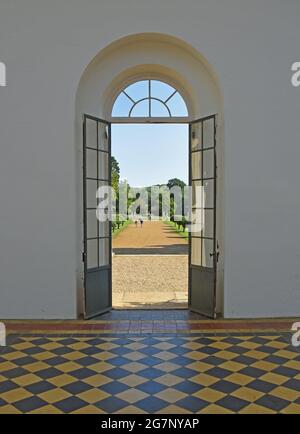 Looking though arched doorway onto outside garden beyond tiled floor. Stock Photo