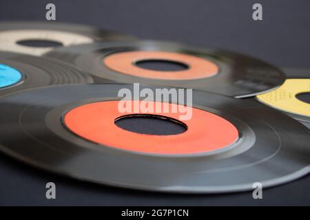 Macro photography of 7 inch single vinyl records on a dark background with selective focus. Background of music or retro concept Stock Photo