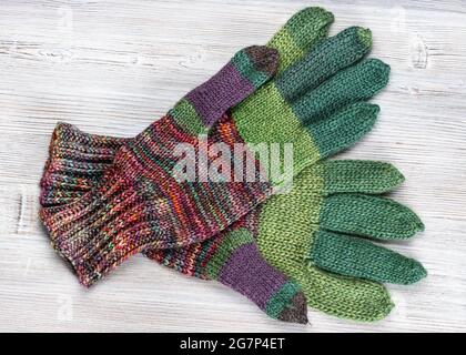 top view of pair of hand knitted woolen gloves on gray wooden table Stock Photo