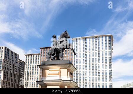 Moscow, Russia - May 23, 2021: old sculpture of pylon of the gate of Central Moscow Hippodrome and modern high-rise apartment houses on Leningradsky P Stock Photo
