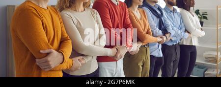 Team of people freelance worker group holding hands together standing in line Stock Photo