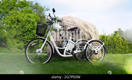 Electric trike or e bicycle in the park in sunny summer day. Shot from the side. A lot of  lighting. The view of the e motor and power battery of the Stock Photo