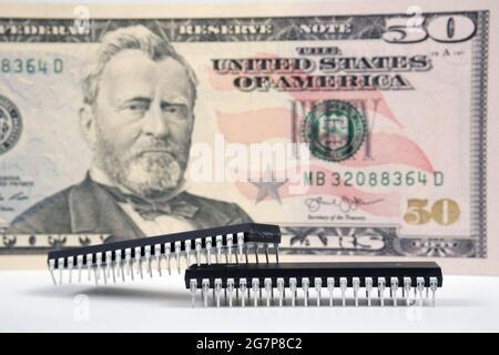 Large computer chips placed next to 50 US dollar banknote. Concept for investment in semiconductor industry and golbal chip shortage. Stock Photo