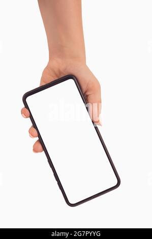 Female hand holding black cellphone with white screen at isolated background from top to bottom. Person holding smartphone with blank white screen. Mo Stock Photo