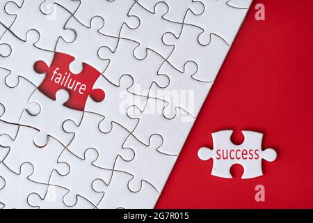 Business concept. Jigsaw puzzle with text failure and success on red background. Selective focus point Stock Photo