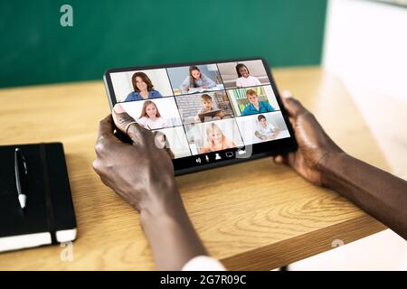 Teacher Hosting Online Class Using Video Conference On Laptop Stock Photo