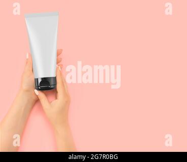 woman holds a tube with a cosmetic product in her hands. mockup woman hand hold Products About white cream tube and beauty products. Skin care concept Stock Photo