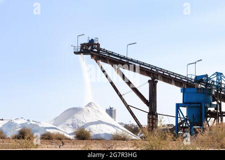 Salt production, conveyor belt with marine salt produced by the evaporation of seawater. Stock Photo