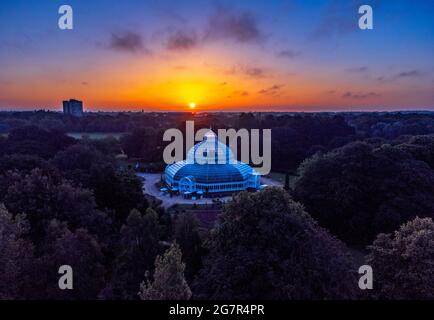 The sun rises behind the Sefton Park Palm House, in Sefton Park, Liverpool, Merseyside, on what is expected to be the hottest day of the year so far. Picture date: Friday July 16, 2021. Stock Photo