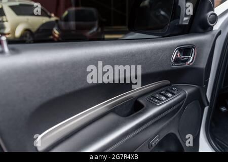 Mirror control knob and window control panel in a modern car. Automatic car window controls and details. Car door lock unlock button. Selective focus Stock Photo