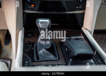 Detail of an automatic gear shifter in a new modern car. Black leather automatic gearbox with chrome detail. Stock Photo