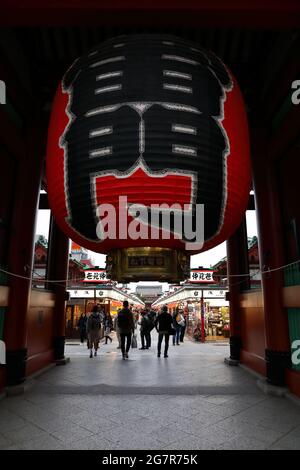 TOKYO, JAPAN - MAY, 2018 : Nakamise-dori view looking under big red paper lantern on the Kaminarimon gate, Sensoji shrine, Asakusa district. Stock Photo