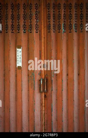 Traditional folding metal security door on a shop in Tai O, Lantau Island, Hong Kong (Translation: 'Entrance, do not block') Stock Photo