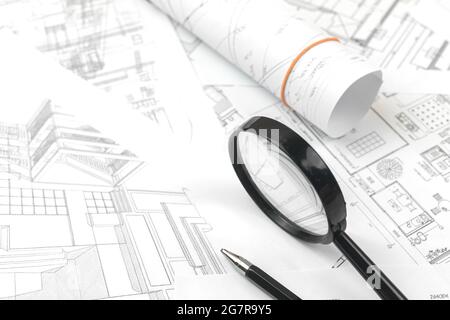 Work project paper blueprints on office table with pen pencil and magnifying glass Stock Photo