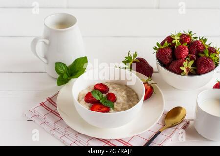 Oatmeal porridge with strawberries in bowl for healthy breakfast. Stock Photo