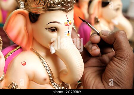Artist painting and giving final touches to Lord Ganesha, ahead of 'Ganesha Chaturthi' festival in Pune. Stock Photo