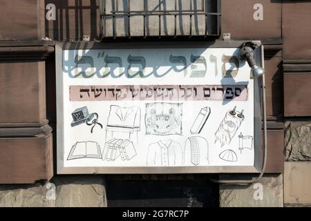 An old weathered Hebrew sign advertising the services of an orthodox Jewish scribe who writes religious items by hand with a feathered quill. Stock Photo