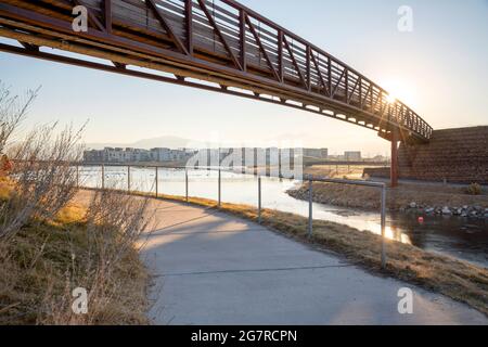 Direct sunlight passing through the footbridge over the paths with metal banister Stock Photo