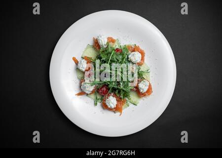 top view of salad with salt salmon, cream cheese or arugula on black background Stock Photo