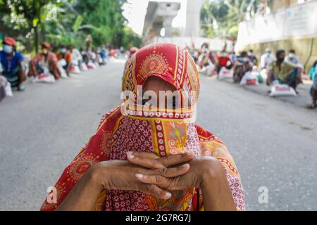 Low income people receive emergency food items provided by Bangladesh Army during the nationwide lockdown to curb the spread of coronavirus (COVID-19) Stock Photo