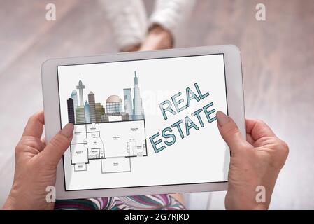 Real estate concept shown on a tablet held by a woman Stock Photo