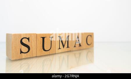 The word sumac was created from wooden letter cubes. Gastronomy and spices. close up. Stock Photo