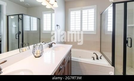 Pano Interior of a master bathroom with double vanity sink and windows Stock Photo