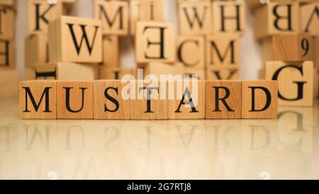 The word Mustard was created from wooden letter cubes. Gastronomy and spices. close up. Stock Photo